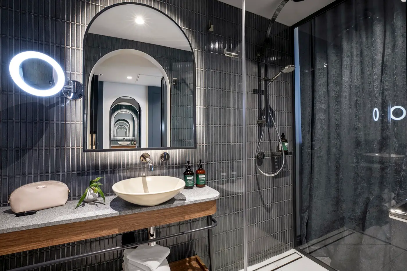 Contemporary bathroom with vessel basin, arched mirror and glass-enclosed walk-in shower