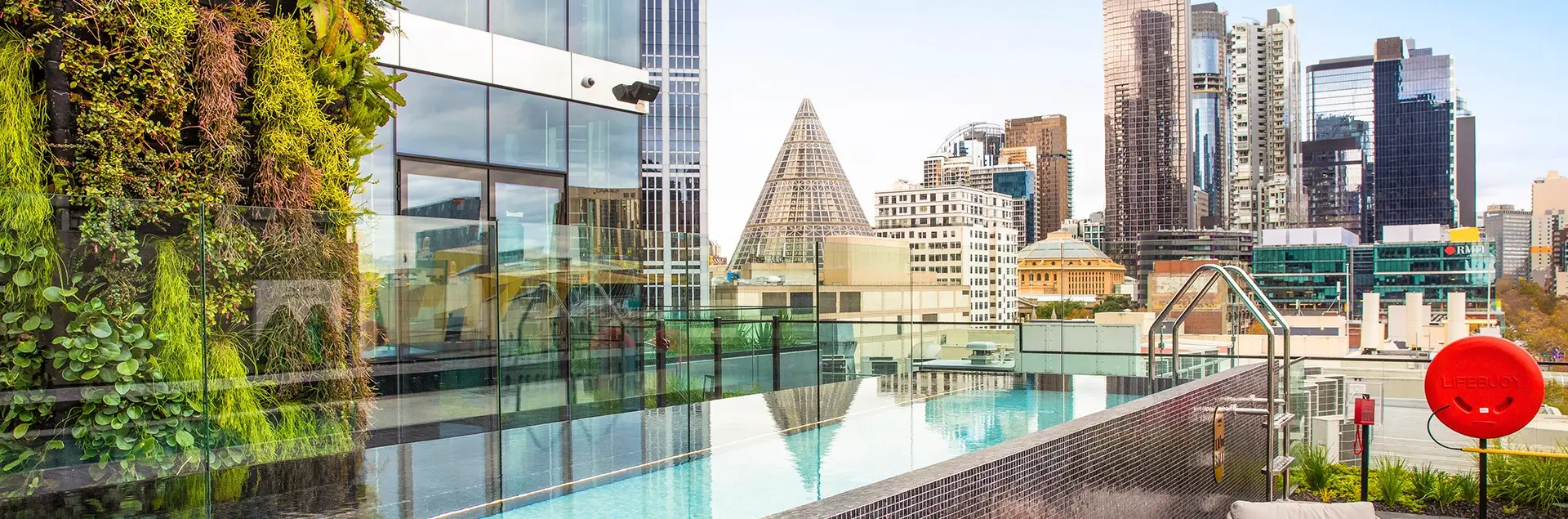 Rooftop pool beside a vertical garden with views across Melbourne’s city skyline