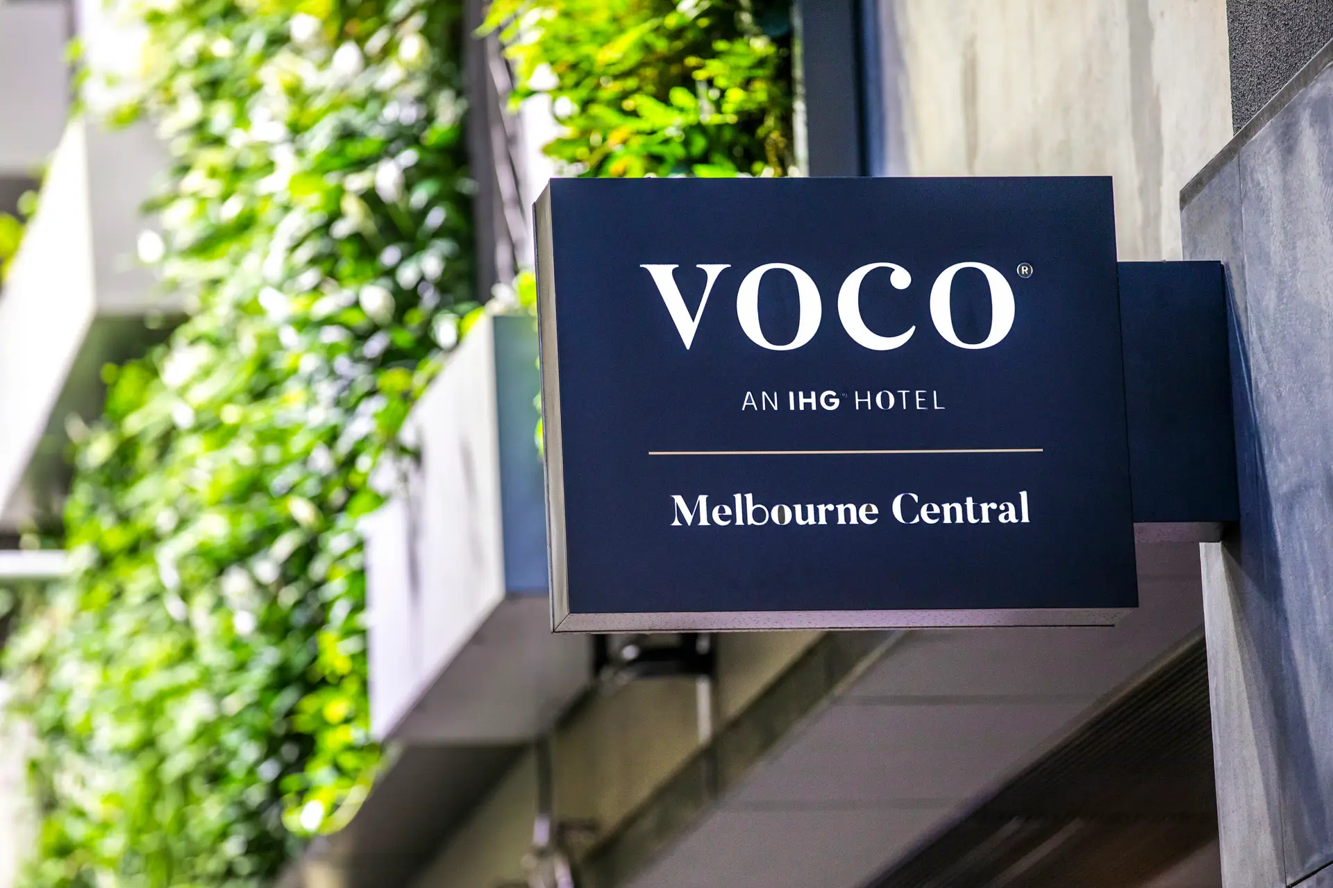 voco Melbourne Central exterior sign mounted beside a green wall