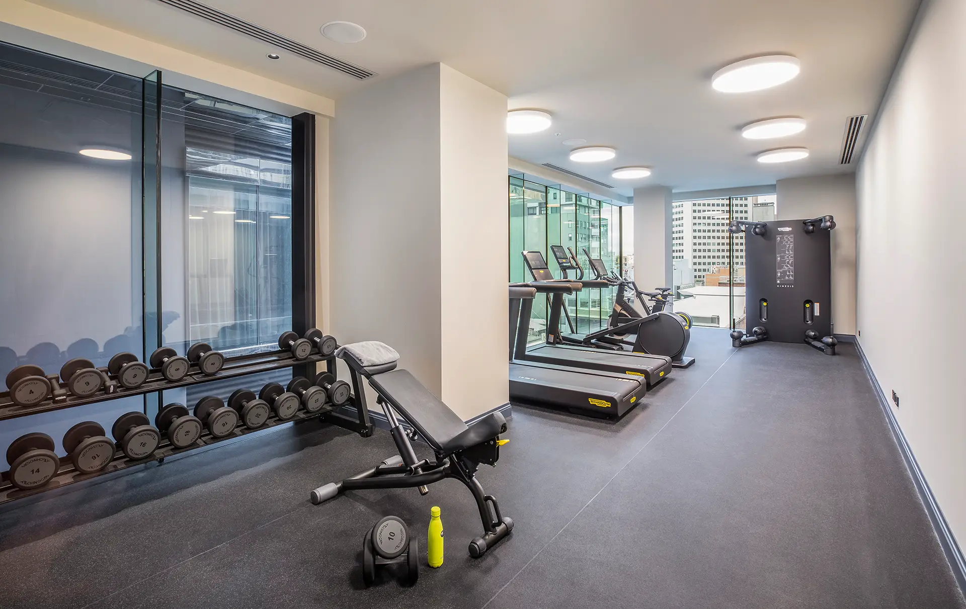 Hotel gym with treadmills, exercise bikes, dumbbells and a weight bench