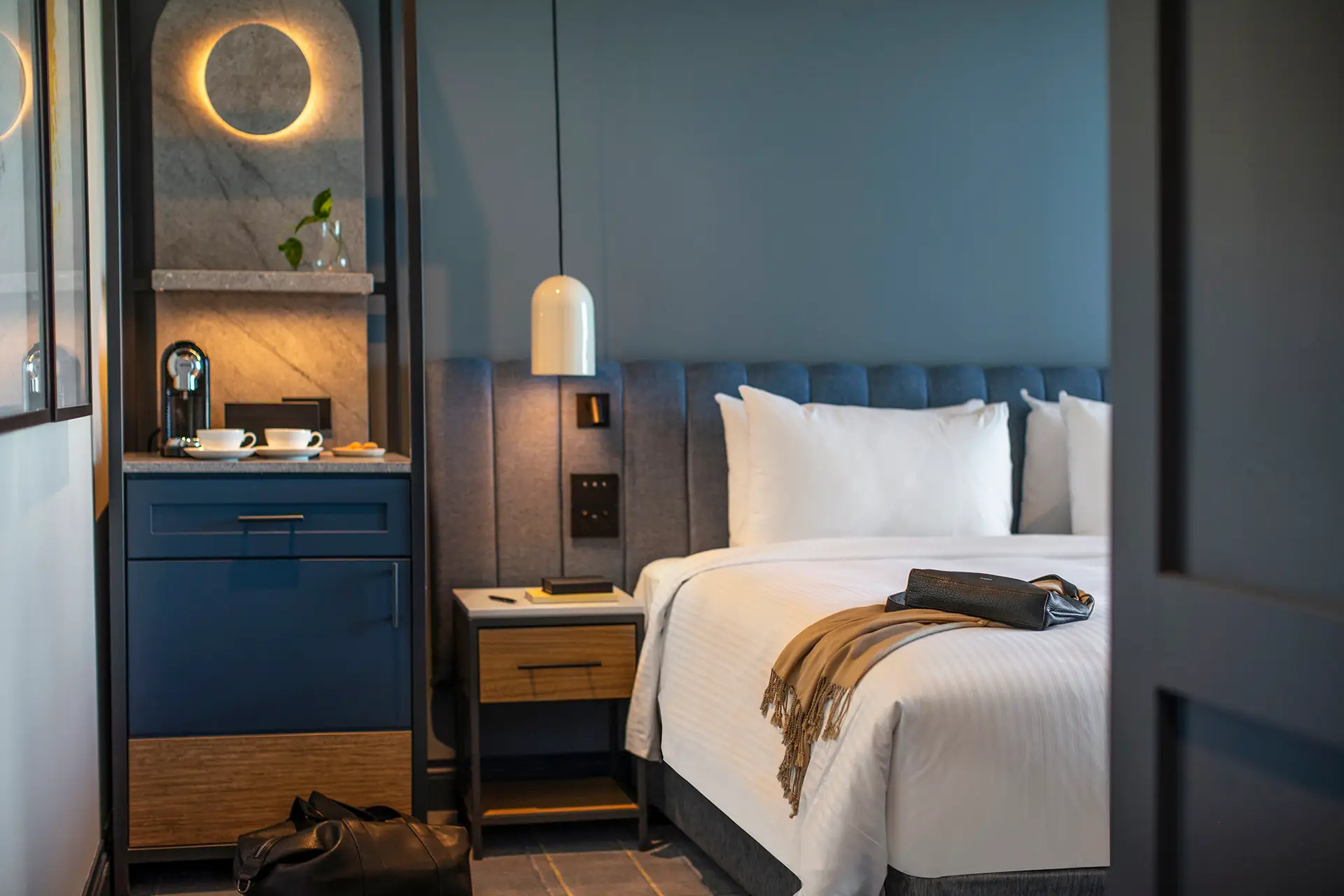 Cozy guest room detail with bed, pendant light and in-room coffee station