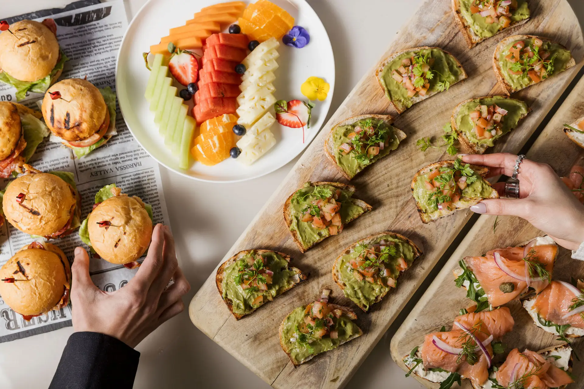 Day delegate catering platters of sliders, fruit and open sandwiches